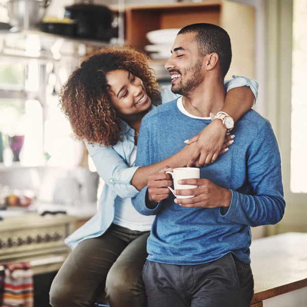 Shot of a happy young couple relaxing in the kitchen in the at home